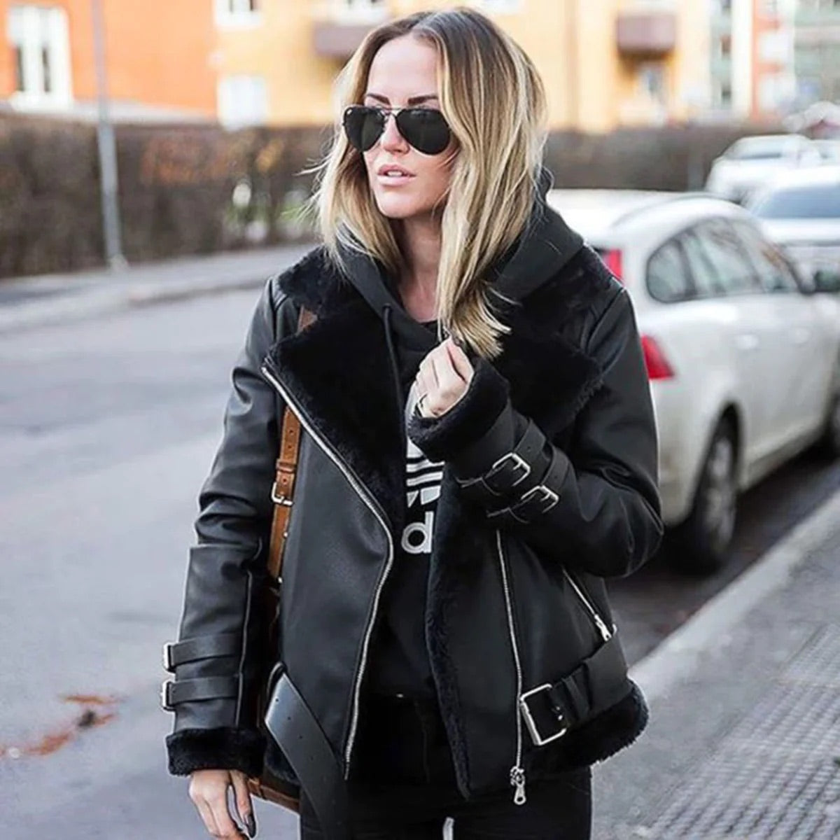 Mujer abrigada con chaqueta de invierno gruesa en la ciudad